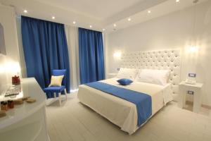 博尔塞纳Ludwig Boutique Hotel & Spa的一间卧室配有一张大床和一张蓝色椅子