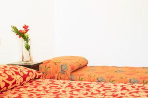 丰特博兰达I Leoncini的两张带枕头的床和一张桌子上的花瓶
