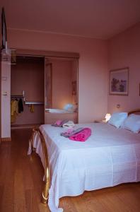 里米尼Villa con piscina a Rimini的卧室配有带粉红色床单的大型白色床