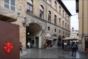 佛罗伦萨Arch Apartment Duomo - Florence的一群人沿着大楼旁边的街道走着
