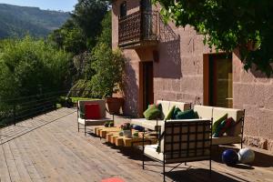 拜昂Casas de Pousadouro的一个带沙发和椅子的庭院和一个阳台