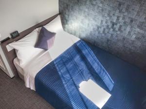 冈山HOTEL LiVEMAX Okayama的一间卧室配有蓝色和白色床单