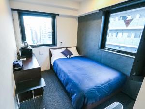 东京HOTEL LiVEMAX Tokyo Shintomicho的一间小卧室,配有床和窗户