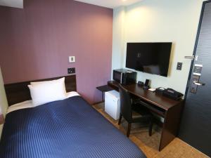 东京HOTEL LiVEMAX Asakusabashi-Eki Kitaguchi的酒店客房配有一张床和一张书桌及一台电视