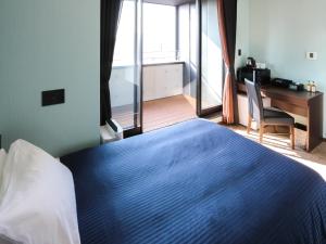 东京HOTEL LiVEMAX Asakusabashi-Eki Kitaguchi的一间卧室配有一张蓝色的床、一张桌子和一个窗户。