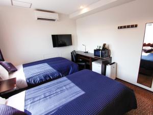 大阪HOTEL LiVEMAX Osaka Dome Mae Hotel的酒店客房配有两张床和一张书桌