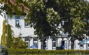 爱尔福特Fürstenhof Landgasthaus & Hotel的一座白色的房子,前面有汽车停放