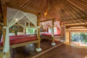 贾蒂卢维普拉纳黛维山区度假酒店的卧室配有一张位于房子内的天蓬床
