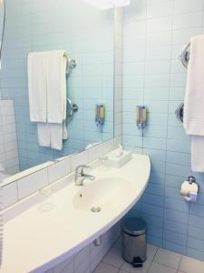 克莱佩达Green Park Hotel Klaipeda的浴室配有盥洗盆、镜子和毛巾