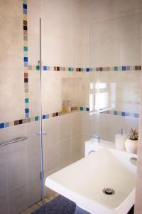 逊邱伦De Zoete Rust Guesthouse的浴室配有白色水槽和淋浴。