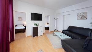 施韦因福特Boardinghouse - Stadtvilla Budget的客厅配有黑色沙发和电视
