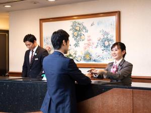 熊本Ark Hotel Kumamotojo Mae -ROUTE INN HOTELS-的男人和女人握手在桌子上