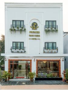 万荣Premier Vang Vieng Hotel的白色的建筑,前方有盆栽植物