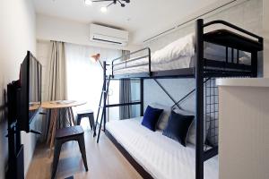 东京KARIO SASAZUKA TERRACE的客房设有两张双层床和一张书桌。