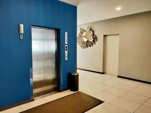 民都鲁Kidurong Inn的走廊上设有金属电梯和蓝色的墙壁