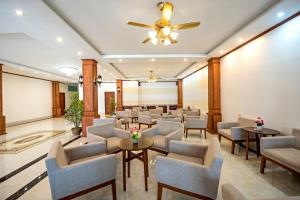 万荣Premier Vang Vieng Hotel的一间设有桌椅和吊扇的等候室