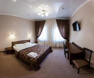 文尼察Отель "София"的配有一张床和一张书桌的酒店客房