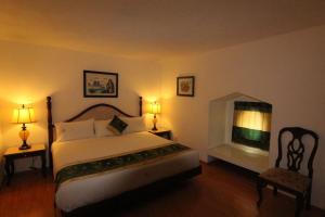 墨西哥城勒阿弗尔酒店的一间卧室设有一张大床和一个壁炉