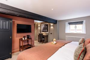 科姆堡城堡酒店的一间卧室配有一张大床和电视
