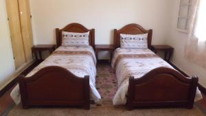 伊夫兰Chalet de la montagne的两张睡床彼此相邻,位于一个房间里
