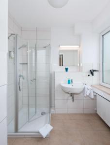 施韦因福特Hotel - Stadtvilla Central的带淋浴和盥洗盆的白色浴室