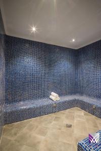 阿可贺巴Normas Hotel的一间蓝色瓷砖浴室,内设长凳