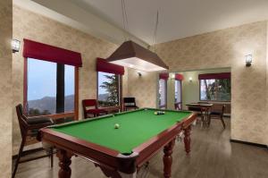西姆拉西姆拉蜜月酒店的台球室,配有台球桌和一些窗户