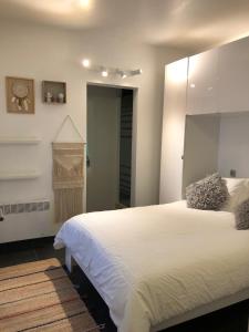 克诺克－海斯特Seawind的卧室配有一张白色大床和镜子