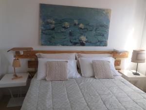 特雷维索阿卡萨帝多拉住宿加早餐旅馆的一张带白色枕头的床和墙上的绘画