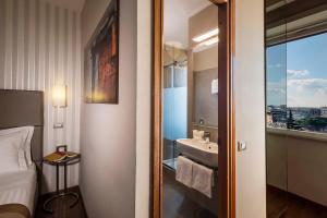 罗马贝斯特韦斯特皮卡迪利酒店的一间卧室,配有带水槽和镜子的浴室