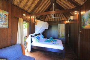 罗威那Villa Rinisha Rumah Senja Temukus Lovina的一间卧室配有一张床和一张蓝色椅子