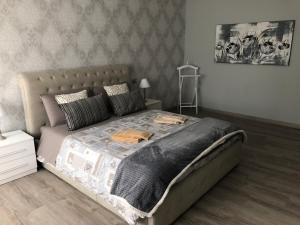 科莫Masia Holiday Apartment Como Lake的一间卧室配有一张大床和灰色的被子
