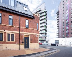 利兹Leeds Super Luxurious Apartments的街上有一道蓝色门的红砖建筑