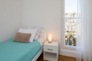 斯普利特Sidro apartment的一间小卧室,配有床和窗户