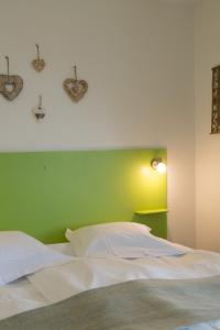 利克维阿加比乡间酒店的一间卧室配有一张白色的床和绿色的墙壁