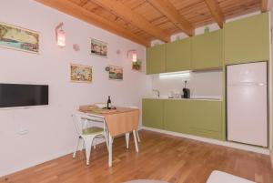 波尔图Rose Green Loft的厨房配有绿色橱柜和桌椅