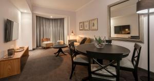 马普托阿凡尼达酒店的一间带桌子的客厅和一间带沙发的房间
