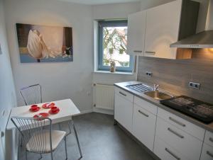AltenbekenFerienwohnung Eggeblick的厨房配有水槽和桌椅