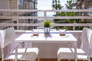 马拉加Malagueta Blue的阳台上配有白色的桌椅