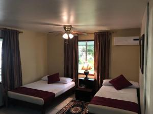 帕拉马里博Overbridge River Resort的一间卧室配有两张床和吊扇