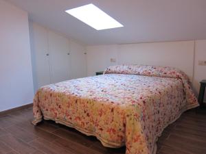 赫尔特EL CHORRO DE JERTE的一间卧室配有一张带花卉床罩的大床