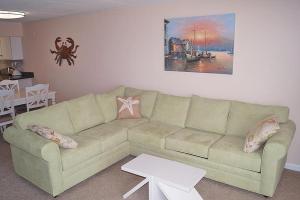 大洋城Ocean Hideaway 205的客厅配有沙发和桌子
