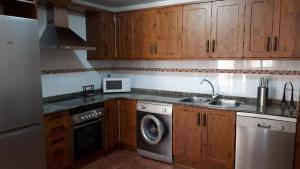 奥里韦拉德尔特雷梅达尔Casa Tere的厨房配有木制橱柜、洗衣机和烘干机