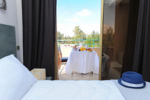 马拉喀什Appart-Hotel Amina Resort的一间带桌子的卧室和一个阳台