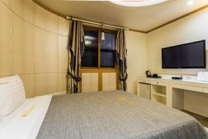 仁川市仁川机场酒店 的一间卧室配有一张床和一台平面电视