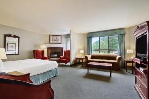 哈里森温泉哈里森湖酒店的大型酒店客房设有一张床和一个壁炉
