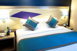 迪拜阿尔萨拉巴酒店的一间卧室配有一张带蓝白色枕头的大床