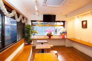 东京Guest House Siesta的餐厅设有两张桌子和鲜花窗户