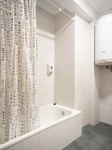 萨拉曼卡Hostal Uría的白色的浴室设有浴缸和淋浴帘