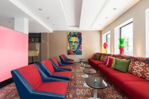诺尔雪平ProfilHotels President的客厅配有红色沙发和蓝色椅子